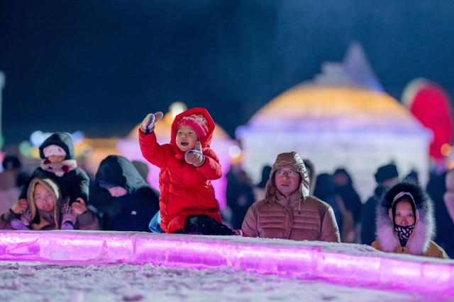 (260101) -- HOHHOT, Jan. 1, 2026 (Xinhua) -- Tourists watch a performance during an ice and snow festival at the Daheihe military cultural park in Hohhot, north China's Inner Mongolia Autonomous Region, Dec. 31, 2025.
  The event kicked off on Wednesday, attracting tourists to enjoy lanterns, ice sculptures and snacks. (Xinhua/Lian Zhen)