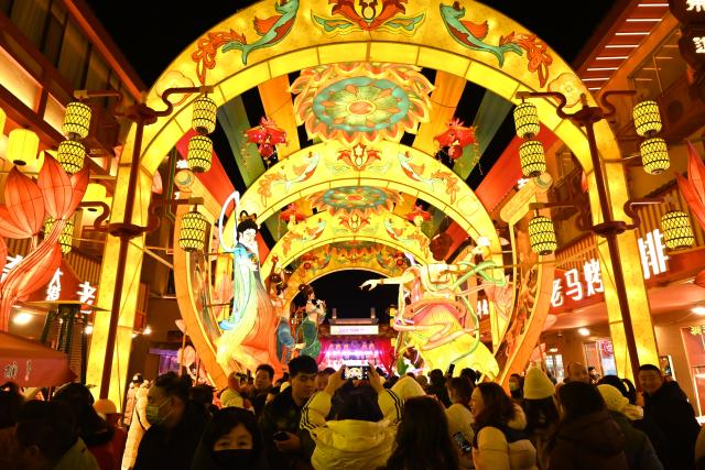 (260101) -- DUNHUANG, Jan. 1, 2026 (Xinhua) -- Tourists visit a lantern fair at a night market in Dunhuang, northwest China's Gansu Province, Dec. 31, 2025.
  The lantern fair kicked off here on Wednesday, attracting many tourists to experience the unique charm of Dunhuang. (Photo by Zhang Xiaoliang/Xinhua)
