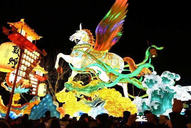 (260101) -- DUNHUANG, Jan. 1, 2026 (Xinhua) -- Tourists visit a lantern fair at a night market in Dunhuang, northwest China's Gansu Province, Dec. 31, 2025.
  The lantern fair kicked off here on Wednesday, attracting many tourists to experience the unique charm of Dunhuang. (Photo by Zhang Xiaoliang/Xinhua)