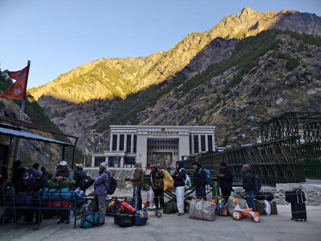 (260101) -- BEIJING, Jan. 1, 2026 (Xinhua) -- This photo taken with a mobile phone shows people waiting for passenger clearance after passing a steel temporary access bridge from China at the Rasuwa Port in Nepal, Jan. 1, 2026. China-Nepal Gyirong-Rasuwa Port, one of the largest land ports between the two countries, resumed customs and passenger clearance on Thursday morning, nearly six months after the area was struck by flood. (Xinhua/Zhang Ping)