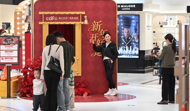 (260101) -- BEIJING, Jan. 1, 2026 (Xinhua) -- A customer poses for photos at a duty-free shop in Haikou, south China's Hainan Province on Jan. 1, 2026. People across China celebrate the arrival of 2026 with a wide range of festivities on Thursday, the first day of the year. (Xinhua/Yang Guanyu)