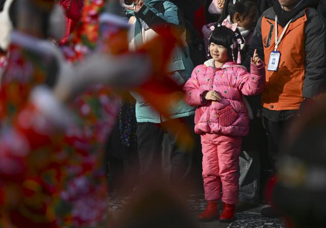 (260101) -- URUMQI, Jan. 1, 2026 (Xinhua) -- A child dances while watching a folk festivity performance at the Xinjiang International Grand Bazaar in Urumqi, northwest China's Xinjiang Uygur Autonomous Region, Jan. 1, 2026. A festive event drew crowds to the Xinjiang International Grand Bazaar on Thursday as people gathered to ring in the New Year. (Xinhua/Wang Fei)