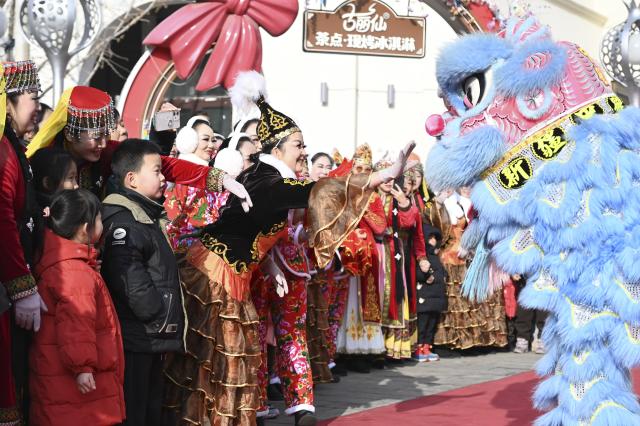 (260101) -- URUMQI, Jan. 1, 2026 (Xinhua) -- Lion dance performers interact with the audience at the Xinjiang International Grand Bazaar in Urumqi, northwest China's Xinjiang Uygur Autonomous Region, Jan. 1, 2026. A festive event drew crowds to the Xinjiang International Grand Bazaar on Thursday as people gathered to ring in the New Year. (Photo by Xu Rui/Xinhua)