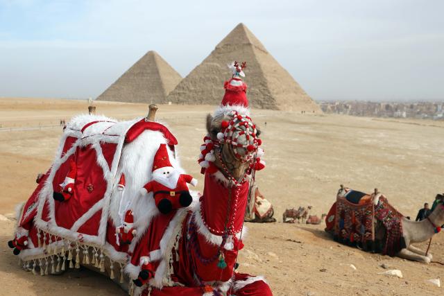 (260101) -- GIZA, Jan. 1, 2026 (Xinhua) -- A camel adorned in Santa Claus-themed decorations is seen at the Pyramids of Giza, Egypt, on Jan.1, 2026. (Xinhua/Ahmed Gomaa)