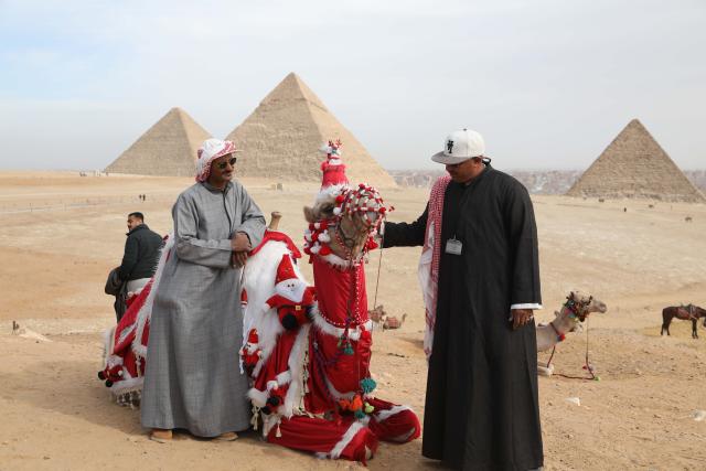(260101) -- GIZA, Jan. 1, 2026 (Xinhua) -- A camel adorned in Santa Claus-themed decorations is seen at the Pyramids of Giza, Egypt, on Jan.1, 2026. (Xinhua/Ahmed Gomaa)