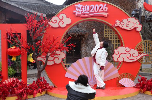 (260101) -- BEIJING, Jan. 1, 2026 (Xinhua) -- A citizen poses for photos with a New Year decoration on a street in Taizhou City, east China's Zhejiang Province, Jan. 1, 2026. People across China celebrate the arrival of 2026 with a wide range of festivities on Thursday, the first day of the year. (Photo by Jiang Youqing/Xinhua)