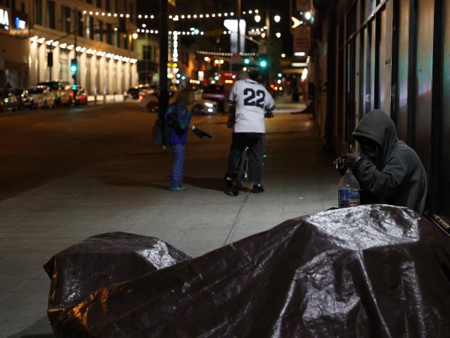 (260101) -- LOS ANGELES, Jan. 1, 2026 (Xinhua) -- A homeless person sits by his tent on the sidewalk in downtown Los Angeles, California, the United States on Dec. 30, 2025. (Photo by Qiu Chen/Xinhua)