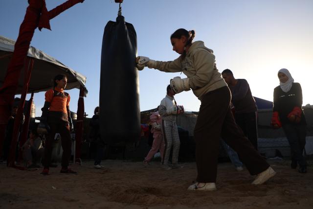 (260101) -- GAZA, Jan. 1, 2026 (Xinhua) -- Palestinian girls take part in a boxing training session aimed for psychological relief and physical empowerment at a displacement camp in the Al-Mawasi area of Khan Younis, southern Gaza Strip, on Dec. 31, 2025. (Photo by Rizek Abdeljawad/Xinhua)