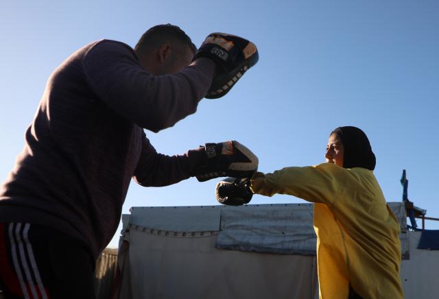 (260101) -- GAZA, Jan. 1, 2026 (Xinhua) -- A Palestinian girl takes part in a boxing training session aimed for psychological relief and physical empowerment at a displacement camp in the Al-Mawasi area of Khan Younis, southern Gaza Strip, on Dec. 31, 2025. (Photo by Rizek Abdeljawad/Xinhua)