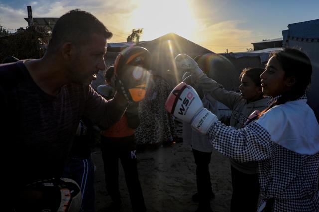 (260101) -- GAZA, Jan. 1, 2026 (Xinhua) -- Palestinian girls take part in a boxing training session aimed for psychological relief and physical empowerment at a displacement camp in the Al-Mawasi area of Khan Younis, southern Gaza Strip, on Dec. 31, 2025. (Photo by Rizek Abdeljawad/Xinhua)