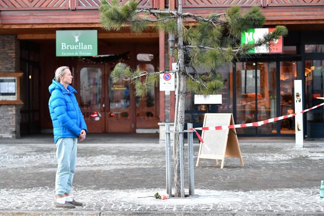 (260101) -- CRANS-MONTANA, Jan. 1, 2026 (Xinhua) -- A woman mourns with flowers at the scene of a fire at a bar in the Crans-Montana ski resort in Valais Canton of southwestern Switzerland, Jan. 1, 2026. Around 40 people died and over 110 others were injured after a fire broke out at a bar in the Crans-Montana ski resort, local police said on Thursday. (Xinhua/Lian Yi)