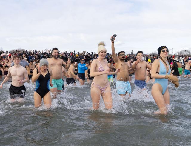 (260102) -- TORONTO, Jan. 2, 2026 (Xinhua) -- Participants rush into Lake Ontario during the Toronto Polar Bear Dip event in Toronto, Canada, on Jan. 1, 2026. Hundreds of people braved the chilly waters here on Thursday to celebrate the first day of 2026 and raise funds for charity. (Photo by Zou Zheng/Xinhua)