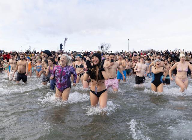 (260102) -- TORONTO, Jan. 2, 2026 (Xinhua) -- Participants rush into Lake Ontario during the Toronto Polar Bear Dip event in Toronto, Canada, on Jan. 1, 2026. Hundreds of people braved the chilly waters here on Thursday to celebrate the first day of 2026 and raise funds for charity. (Photo by Zou Zheng/Xinhua)