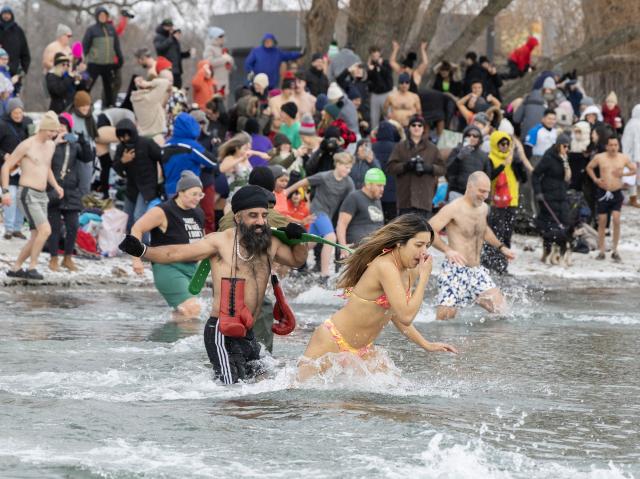 (260102) -- TORONTO, Jan. 2, 2026 (Xinhua) -- Participants rush into Lake Ontario during the Toronto Polar Bear Dip event in Toronto, Canada, on Jan. 1, 2026. Hundreds of people braved the chilly waters here on Thursday to celebrate the first day of 2026 and raise funds for charity. (Photo by Zou Zheng/Xinhua)