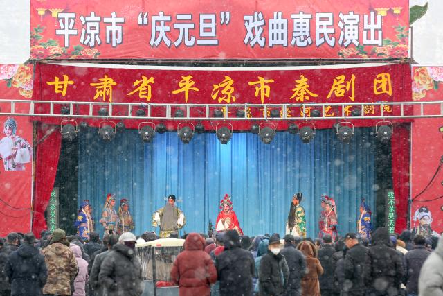 (260102) -- BEIJING, Jan. 2, 2026 (Xinhua) -- People watch an opera performance in snow in Pingliang, northwest China's Gansu Province Jan. 2, 2026 China's economy kicked off 2026 with robust momentum, as evidenced by bustling economic activity in the year's first days. (Photo by Wu Xihui/Xinhua)