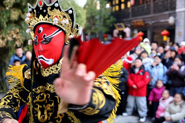 (260102) -- BEIJING, Jan. 2, 2026 (Xinhua) -- A folk artist is pictured during "bianlian," a face-changing performance featured in Sichuan Opera, in Taierzhuang ancient town of Zaozhuang, east China's Shandong Province, Jan. 1, 2026. China's economy kicked off 2026 with robust momentum, as evidenced by bustling economic activity in the year's first days. (Photo by Sun Zhongzhe/Xinhua)