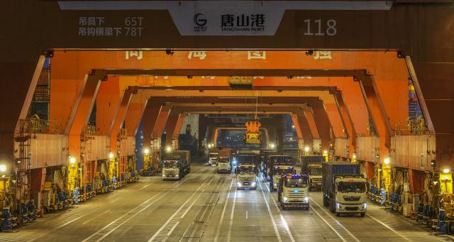 (260102) -- BEIJING, Jan. 2, 2026 (Xinhua) -- A drone phone taken on Jan. 2, 2026 shows trucks loaded with containers at the Tangshan Port in Tangshan, north China's Hebei Province. China's economy kicked off 2026 with robust momentum, as evidenced by bustling economic activity in the year's first days. (Photo by Liu Mancang/Xinhua)
