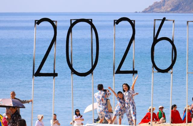 (260102) -- BEIJING, Jan. 2, 2026 (Xinhua) -- Tourists pose for photos at a scenic area in Sanya, south China's Hainan Province, Jan. 1, 2026. China's economy kicked off 2026 with robust momentum, as evidenced by bustling economic activity in the year's first days. (Photo by Li Xueshi/Xinhua)