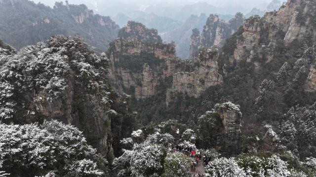 (260102) -- CHANGSHA, Jan. 2, 2026 (Xinhua) -- An aerial drone photo taken on Jan. 2, 2026 shows people enjoying the snow scenery at Zhangjiajie National Forest Park in Zhangjiajie, central China's Hunan Province. (Xinhua/Chen Zhenhai)