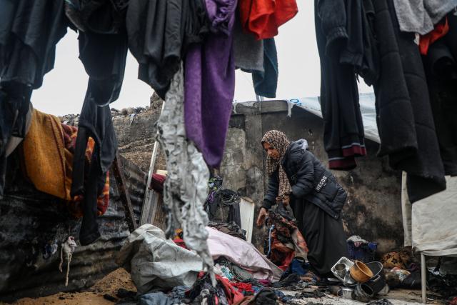 (260102) -- GAZA, Jan. 2, 2026 (Xinhua) -- A displaced Palestinian woman inspects the damage to her temporary tent after a fire broke out the previous night, in Gaza City on Jan. 2, 2026. (Photo by Rizek Abdeljawad/Xinhua)