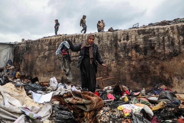 (260102) -- GAZA, Jan. 2, 2026 (Xinhua) -- A displaced Palestinian woman inspects the damage to her temporary tent after a fire broke out the previous night, in Gaza City on Jan. 2, 2026. (Photo by Rizek Abdeljawad/Xinhua)