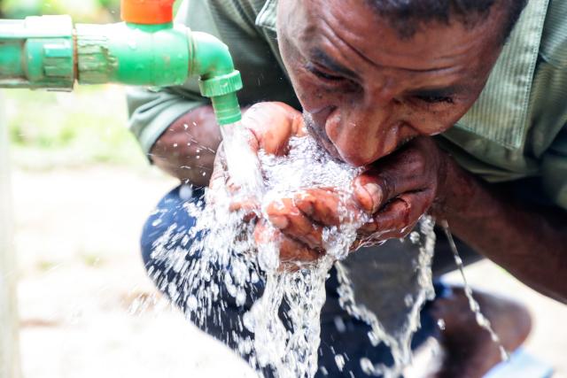 (260102) -- ZANZIBAR, Jan. 2, 2026 (Xinhua) -- A resident drinks clean water directly from a public tap in Chaani village on Unguja Island, Zanzibar, Tanzania, Dec. 31, 2025. TO GO WITH "Feature: Where clean water flows, disease recedes: China's schistosomiasis control effort saves lives in Zanzibar" (Xinhua/Emmanuel Herman)