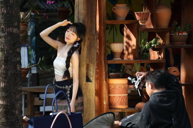 (260103) -- BEIJING, Jan. 3, 2026 (Xinhua) -- Tourists take photos at an ancient hamlet in Jinghong, southwest China's Yunnan Province, on Jan. 2, 2026. (Photo by Li Yunsheng/Xinhua)