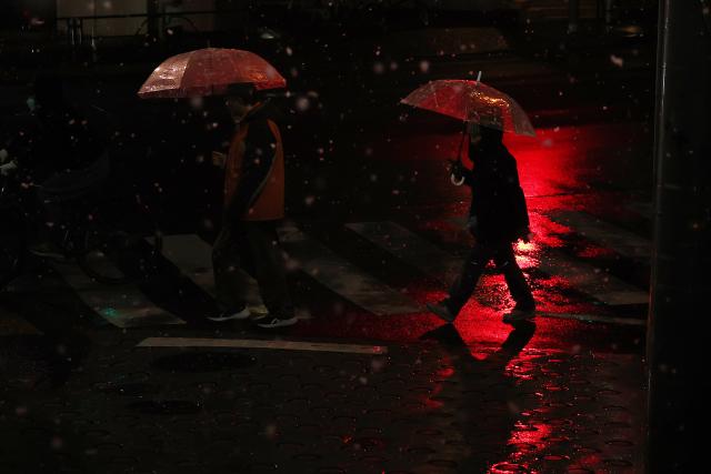 (260103) -- BEIJING, Jan. 3, 2026 (Xinhua) -- People walk on a street on the first snow day of 2026 in Tokyo, Japan, Jan. 2, 2026. (Xinhua/Jia Haocheng)