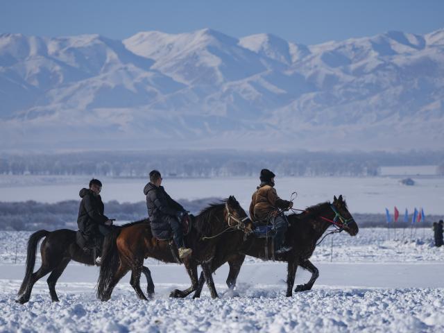 (260103) -- ZHAOSU, Jan. 3, 2026 (Xinhua) -- Tourists ride horses under the lead of a herder (R) at a wetland park in Zhaosu County, Ili Kazak Autonomous Prefecture, northwest China's Xinjiang Uygur Autonomous Region, Jan. 3, 2026. Leveraging its unique ice and snow resources in winter, Zhaosu County has developed diverse winter tourist services to attract visitors. (Xinhua/Hu Huhu)