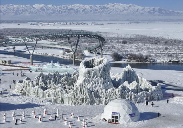 (260103) -- ZHAOSU, Jan. 3, 2026 (Xinhua) -- An aerial drone photo taken on Jan. 3, 2026 shows people enjoying themselves at an ice-and-snow themed park in Zhaosu County, Ili Kazak Autonomous Prefecture, northwest China's Xinjiang Uygur Autonomous Region. Leveraging its unique ice and snow resources in winter, Zhaosu County has developed diverse winter tourist services to attract visitors. (Xinhua/Hu Huhu)