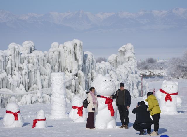 (260103) -- ZHAOSU, Jan. 3, 2026 (Xinhua) -- People take photos at an ice-and-snow themed park in Zhaosu County, Ili Kazak Autonomous Prefecture, northwest China's Xinjiang Uygur Autonomous Region, Jan. 3, 2026. Leveraging its unique ice and snow resources in winter, Zhaosu County has developed diverse winter tourist services to attract visitors. (Xinhua/Hu Huhu)