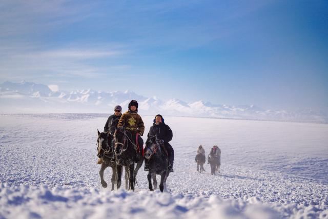 (260103) -- ZHAOSU, Jan. 3, 2026 (Xinhua) -- Tourists (1st and 3rd, L) ride horses at a wetland park in Zhaosu County, Ili Kazak Autonomous Prefecture, northwest China's Xinjiang Uygur Autonomous Region, Jan. 3, 2026. Leveraging its unique ice and snow resources in winter, Zhaosu County has developed diverse winter tourist services to attract visitors. (Xinhua/Xu Hongyan)