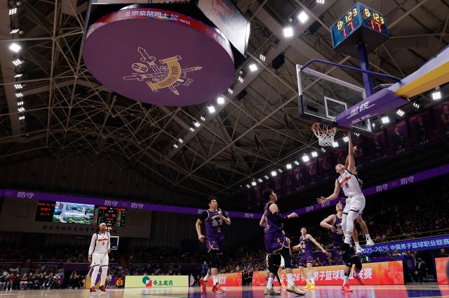 (260103) -- BEIJING, Jan. 3, 2026 (Xinhua) -- Hu Mingxuan (R) of Guangdong Southern Tigers goes for a basket during the 10th round regular season match between Beijing Royal Fighters and Guangdong Southern Tigers at the 2025-2026 Chinese Basketball Association (CBA) league in Beijing, China, Jan. 3, 2026. (Xinhua/Wang Lili)