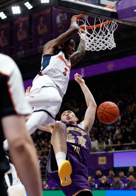 (260103) -- BEIJING, Jan. 3, 2026 (Xinhua) -- Edmond Sumner (L) of Guangdong Southern Tigers dunks over Jiang Linjun of Beijing Royal Fighters during the 10th round regular season match at the 2025-2026 Chinese Basketball Association (CBA) league in Beijing, China, Jan. 3, 2026. (Xinhua/Wang Lili)