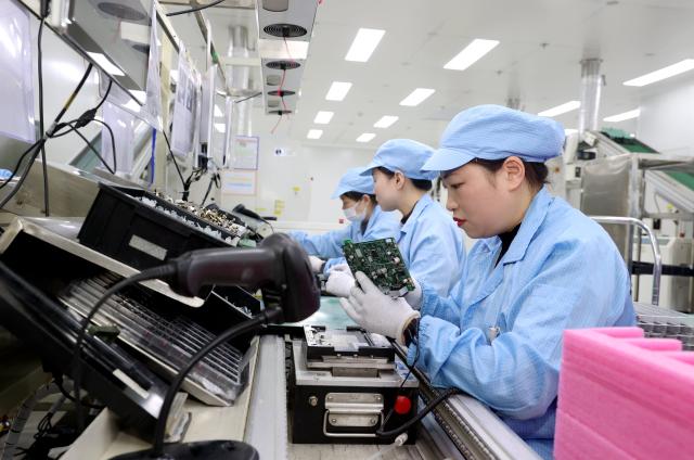 (260104) -- BEIJING, Jan. 4, 2026 (Xinhua) -- Workers operate on a production line of automotive intelligent central control navigation products at the workshop of a company in Suqian New & Hi-tech Industry Development Zone of Suqian City, east China's Jiangsu Province, Jan. 4, 2026. (Photo by Wang Li/Xinhua)
