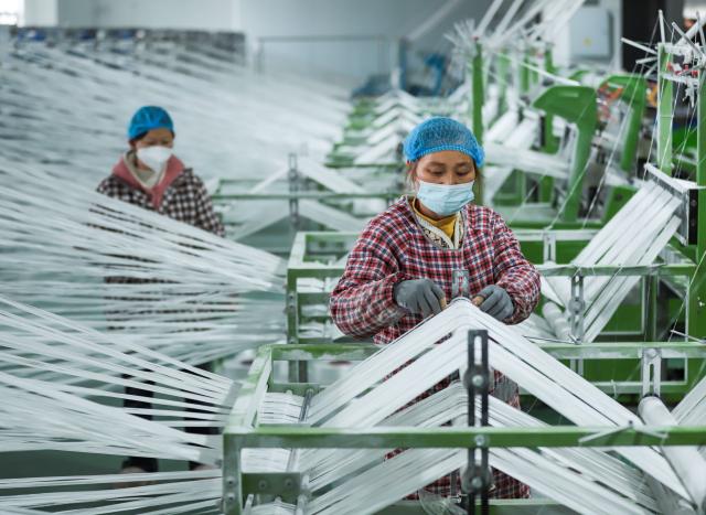 (260104) -- BEIJING, Jan. 4, 2026 (Xinhua) -- Workers operate on a production line at the jumbo bag workshop of a packaging company in Yuping Dong Autonomous County of Tongren, southwest China's Guizhou Province, Jan. 4, 2026. (Photo by Xu Xue/Xinhua)
