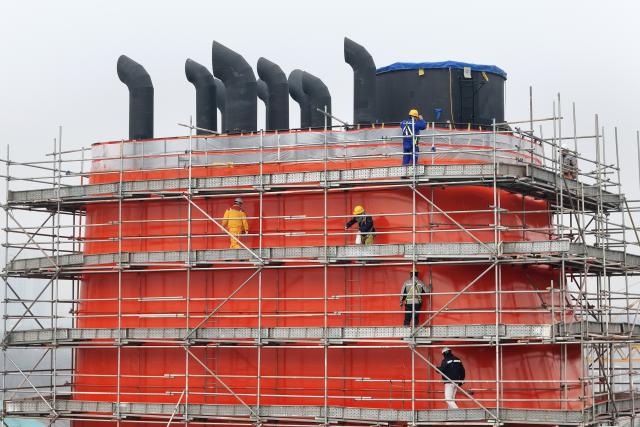 (260104) -- BEIJING, Jan. 4, 2026 (Xinhua) -- A drone photo taken on Jan. 4, 2026 shows staff members checking the quality of a part of a ship at a shipyard in Yantai, east China's Shandong Province. (Photo by Tang Ke/Xinhua)