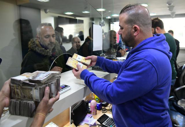 (260105) -- DAMASCUS, Jan. 5, 2026 (Xinhua) -- Syrian citizens exchange newly issued Syrian pound banknotes at a designated exchange point in Damascus, Syria, Jan. 4, 2026. Syria has begun circulating its new currency following a nationwide exchange process launched earlier this month. (Photo by Ammar Safarjalani/Xinhua)