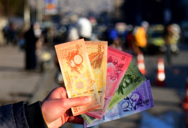 (260105) -- DAMASCUS, Jan. 5, 2026 (Xinhua) -- A Syrian citizen shows newly issued Syrian pound banknotes at a designated exchange point in Damascus, Syria, Jan. 4, 2026. Syria has begun circulating its new currency following a nationwide exchange process launched earlier this month. (Photo by Ammar Safarjalani/Xinhua)