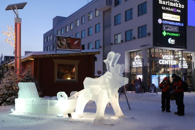 (260105) -- ROVANIEMI, Jan. 5, 2026 (Xinhua) -- People view an ice sculpture depicting a reindeer pulling a sleigh in Rovaniemi, Finland, Jan. 2, 2026. Rovaniemi, a city located on the Arctic Circle, is renowned worldwide for aurora watching, winter sports, and reindeer sleigh rides. It is also well known internationally as the "home of Santa Claus," attracting large numbers of visitors from around the globe. (Xinhua/Zhu Haochen)
