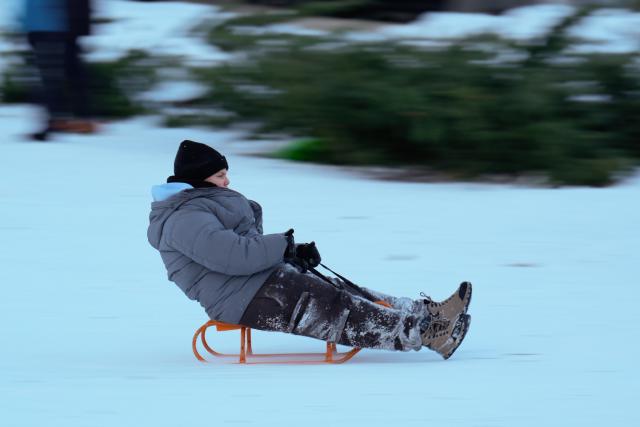 (260105) -- WARSAW, Jan. 5, 2026 (Xinhua) -- A child rides a sled at a park in Warsaw, Poland on Jan. 4, 2026. Warsaw has recently seen continuous snowfall, bringing residents outdoors to enjoy winter activities. (Photo by Jaap Arriens/Xinhua)