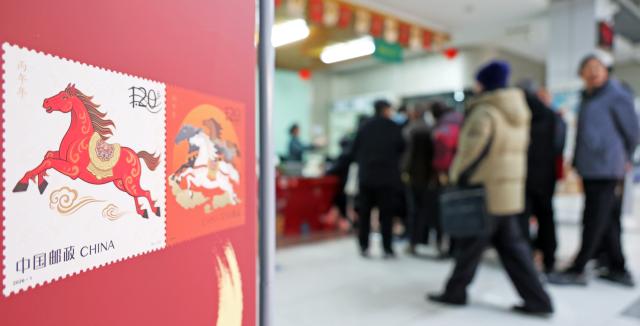 (260105) -- LIANYUNGANG, Jan. 5, 2026 (Xinhua) -- People buy special stamps marking the Year of the Horse in Lianyungang, east China's Jiangsu Province, Jan. 5, 2026. China Post on Monday unveiled a set of two special stamps to celebrate the upcoming Chinese zodiac Year of the Horse. (Photo by Geng Yuhe/Xinhua)