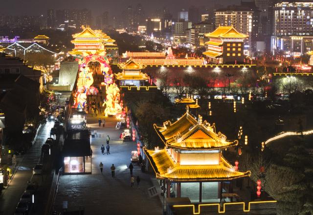 (260105) -- XI'AN, Jan. 5, 2026 (Xinhua) -- An aerial drone photo taken on Jan. 4, 2026 shows tourists watching lanterns on the ancient city wall of Xi'an during a lantern festival in Xi'an, northwest China's Shaanxi Province. A lantern festival is held here to mark the upcoming Chinese Lunar New Year. (Xinhua/Shao Rui)