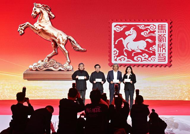 (260105) -- BEIJING, Jan. 5, 2026 (Xinhua) -- Guests show the commemorative seal marking the Year of the Horse during an issuance ceremony in Beijing, capital of China, Jan. 5, 2026. China Post on Monday unveiled a set of two special stamps to celebrate the upcoming Chinese zodiac Year of the Horse. (Xinhua/Li He)