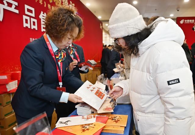 (260105) -- BEIJING, Jan. 5, 2026 (Xinhua) -- People buy special stamps marking the Year of the Horse and related products in Beijing, capital of China, Jan. 5, 2026. China Post on Monday unveiled a set of two special stamps to celebrate the upcoming Chinese zodiac Year of the Horse. (Xinhua/Li He)