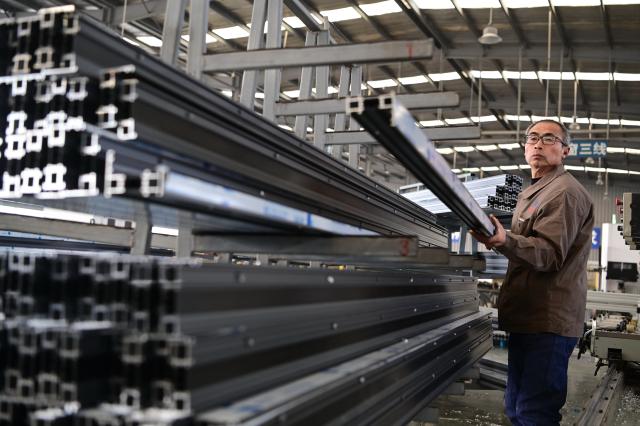 (260105) -- BEIJING, Jan. 5, 2026 (Xinhua) -- A worker produces aluminum alloy doors and windows at a factory in Qinyang, central China's Henan Province, Jan. 5, 2026. At the start of 2026, businesses across China are already busy fulfilling orders and ramping up production, aiming for a sound performance in the first quarter. (Photo by Yang Fan/Xinhua)