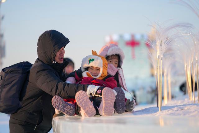 (260105) -- HARBIN, Jan. 5, 2026 (Xinhua) -- Visitors enjoy themselves at the Harbin Ice-Snow World in Harbin, northeast China's Heilongjiang Province, Jan. 5, 2026. The 42nd Harbin International Ice and Snow Festival kicked off at the Harbin Ice-Snow World here on Monday. (Xinhua/Wang Jianwei)
