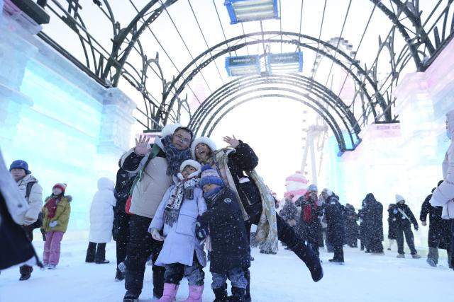 (260105) -- HARBIN, Jan. 5, 2026 (Xinhua) -- Visitors pose for photos at the Harbin Ice-Snow World in Harbin, northeast China's Heilongjiang Province, Jan. 5, 2026. The 42nd Harbin International Ice and Snow Festival kicked off at the Harbin Ice-Snow World here on Monday. (Xinhua/Wang Song)