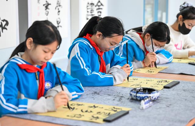 (260106) -- TIANJIN, Jan. 6, 2026 (Xinhua) -- Students write calligraphy at the Yangcun No. 14 Primary School in Wuqing District of Tianjin, north China, Jan. 6, 2026. In recent years, this school has offered a series of classes and activities featuring traditional culture for students to experience. (Xinhua/Zhao Zishuo)