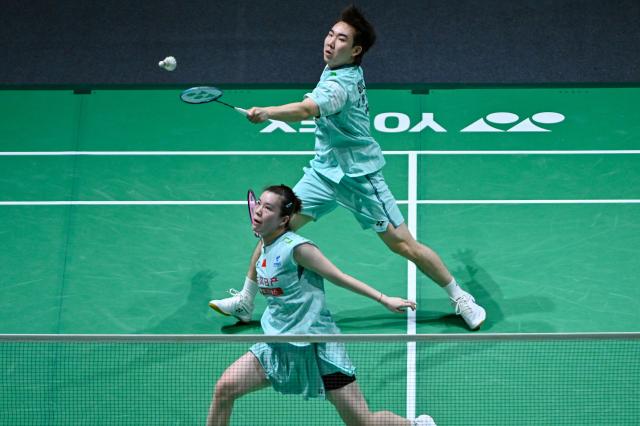 (260106) -- KUALA LUMPUR, Jan. 6, 2026 (Xinhua) -- Guo Xinwa (top)/Cheng Fanghui of China compete during the mixed doubles round of 32 match against Alexander Dunn/Julie Macpherson of Scotland at the Malaysia Open 2026 badminton tournament in Kuala Lumpur, Malaysia, Jan. 6, 2026. (Photo by Chong Voon Chung/Xinhua)